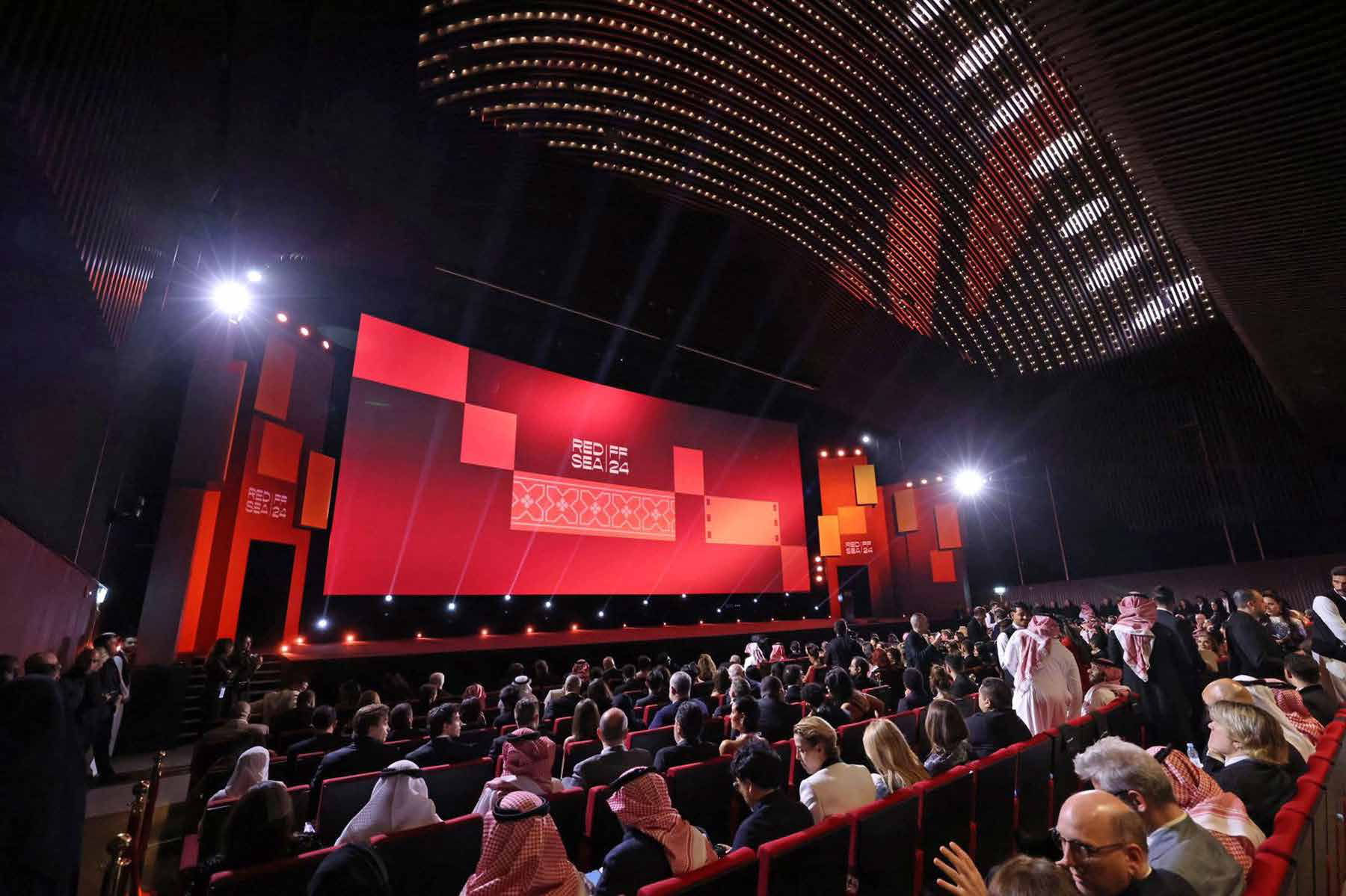 Packed auditorium at the Red Sea International Film Festival in Jeddah, with the main screen lit