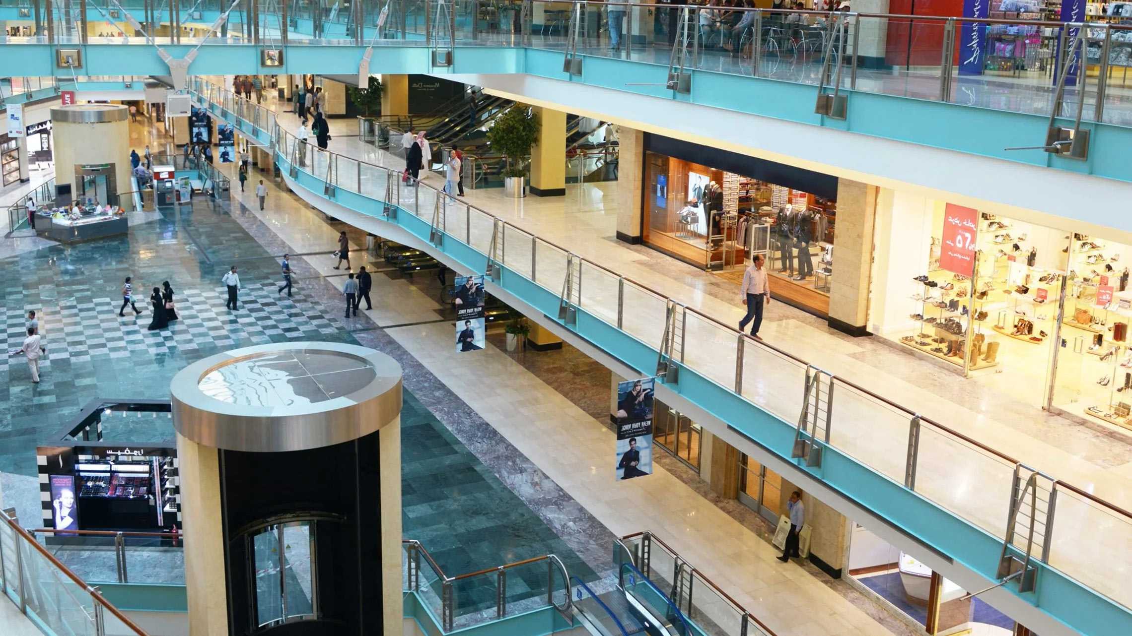 Busy multi-level shopping mall interior in Dubai with shoppers and retail storefronts