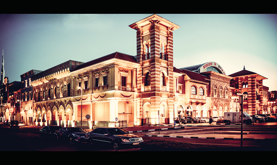 Mercato Mall exterior at dusk with its Italianate façade and clock tower illuminated