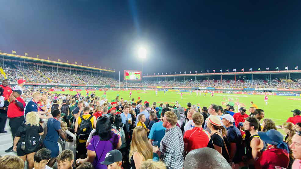 Packed crowd watching a match under floodlights at The Sevens Stadium in Dubai