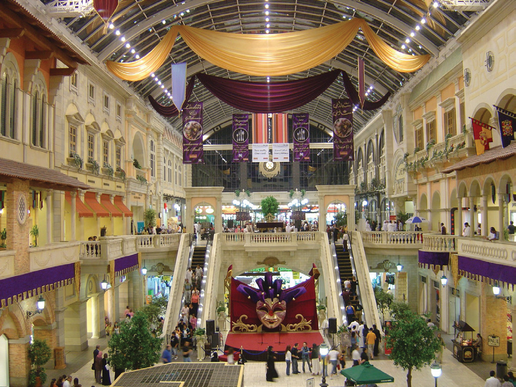 Interior atrium at Mercato Mall with shoppers, escalators and a central event stage
