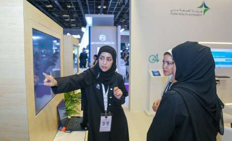 Dubai Health Authority staff at an exhibition stand demonstrating digital health services