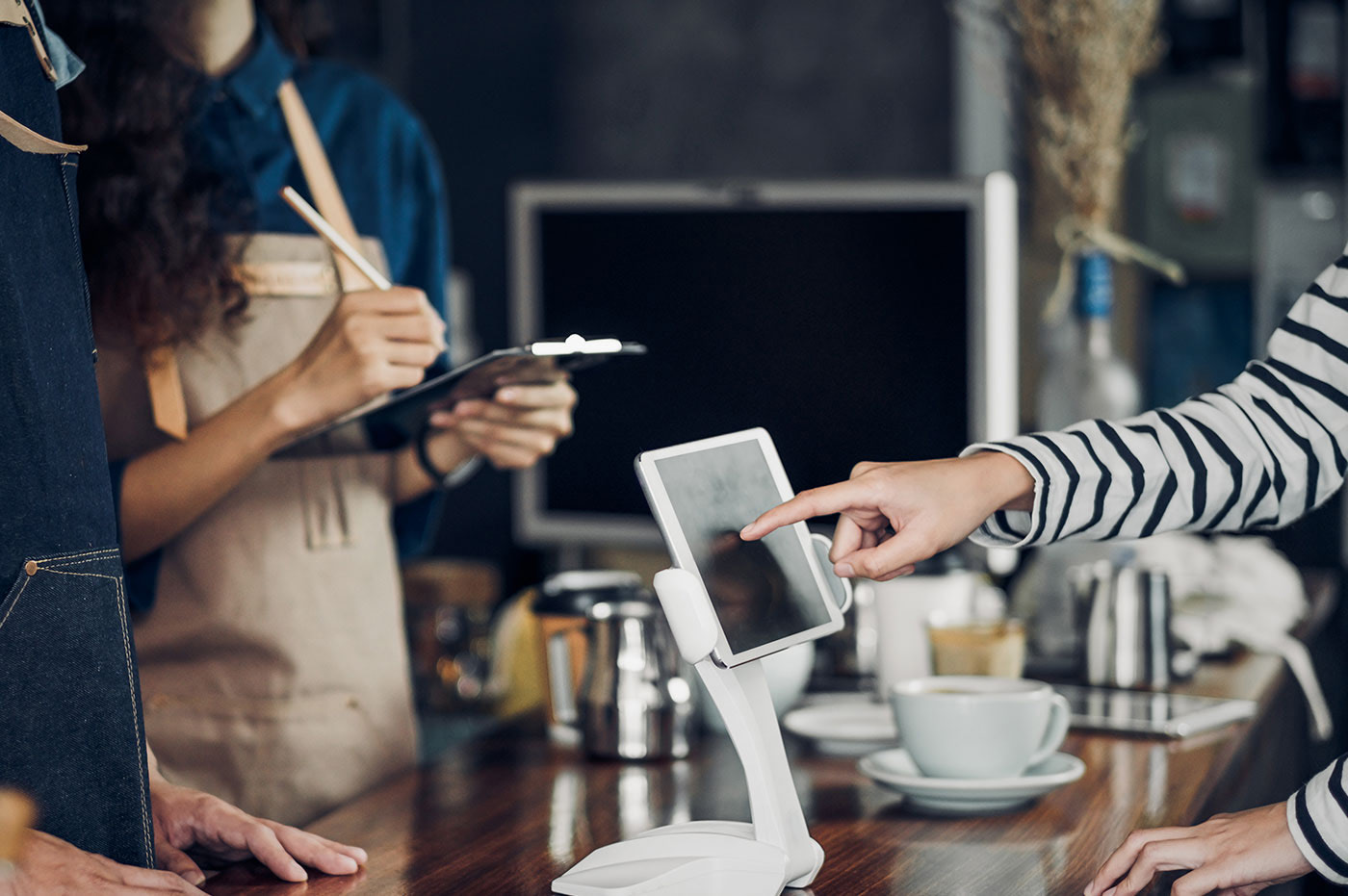 Customer ordering at a café counter using a tablet point-of-sale screen