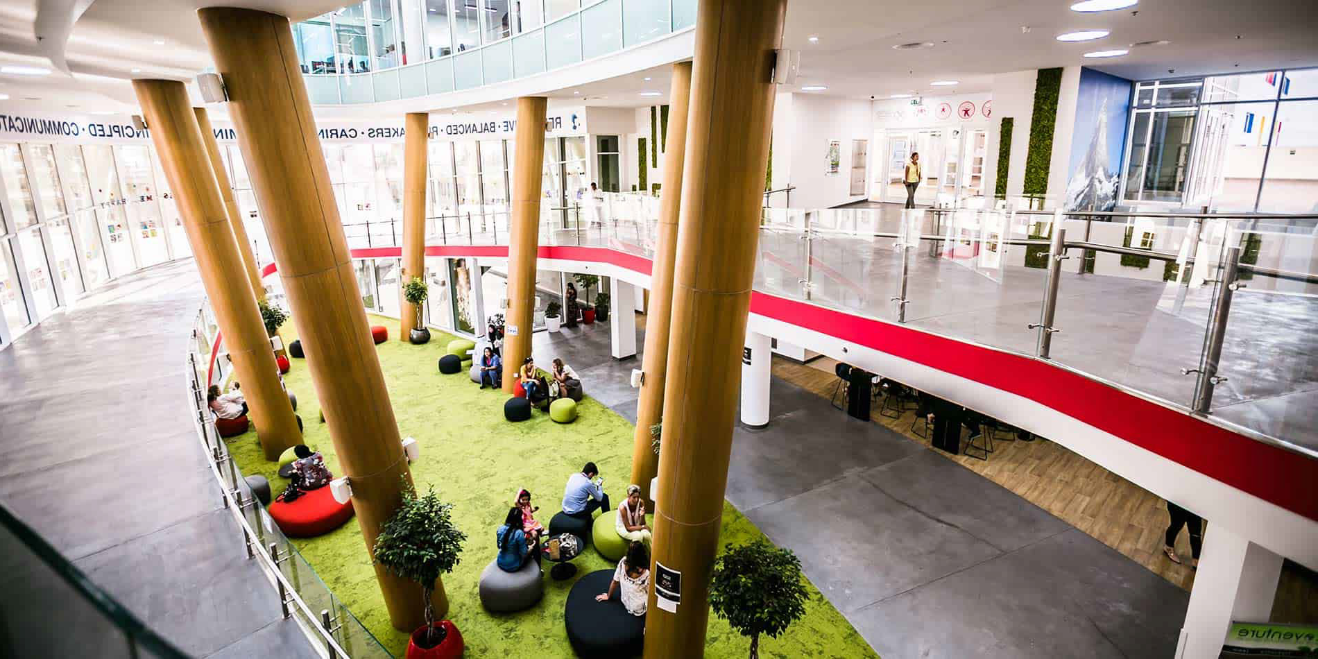 The SISD Dubai atrium with students seated in open study areas across two levels