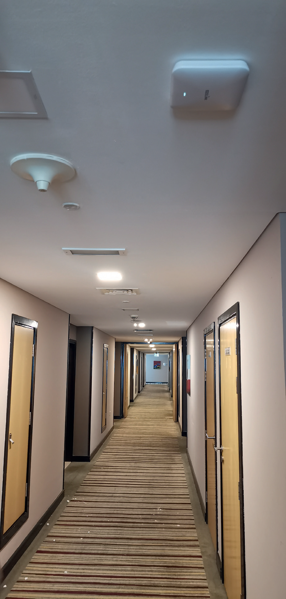 EZELINK access point installed on a guest corridor ceiling at a Citymax hotel, status light lit