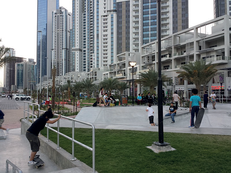 Outdoor community plaza and skate park at Bay Avenue with Business Bay towers behind