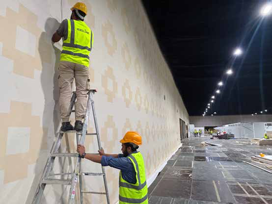 EZELINK engineers installing wireless hardware on a festival venue wall from a ladder