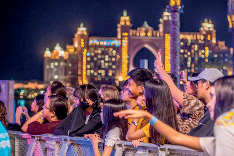 Concert crowd at The Pointe at night with the Atlantis hotel illuminated behind