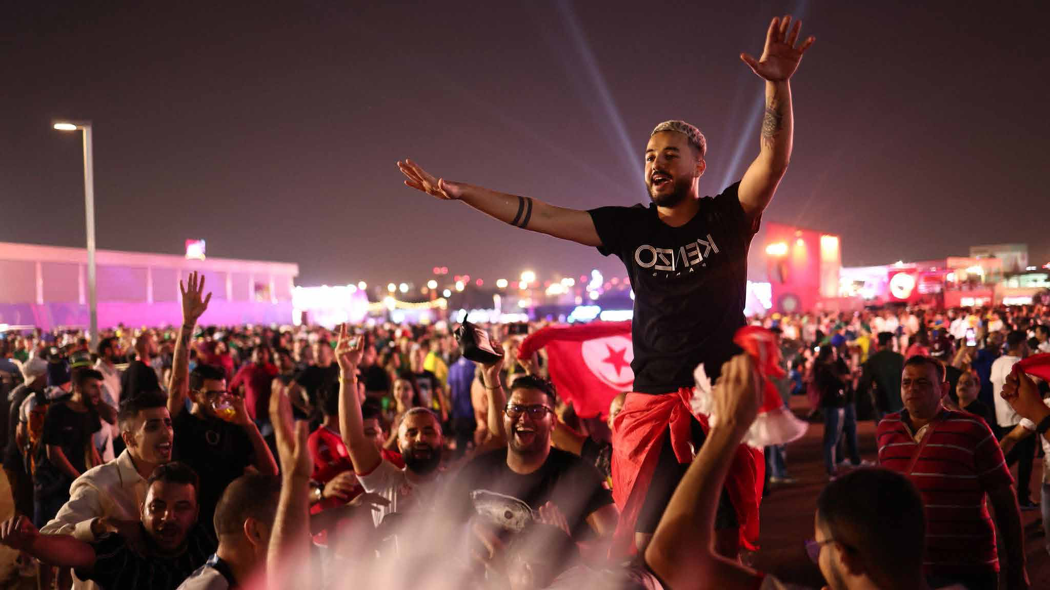 Crowds celebrating at a World Cup fan zone in Qatar at night